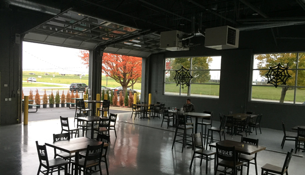A patron enjoys a brew at the indoor/outdoor dining room at More Brewery Company. The microbrewery is in Kane County and has been operating under COVID-19 mitigating restrictions since last Friday, only seating people with the roll-up doors open.
