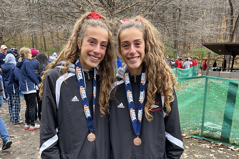 Huntley twin sisters Breanna Burak, left and Brittney Bura, show off their all-state medals earned at the Class 3A IHSA State Cross Country meet. Breanna finished 12th and Brittney was 21st.
