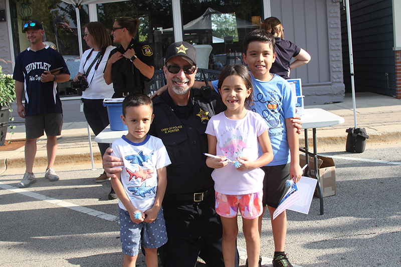 Huntley Police Department hosted National Night Out (NNO) at Huntley Town Square Aug. 1. Posing with Police Chief Robert Porter are Erick Vazquez, age 5, Nora Vazquez, age 7 and Aaron Vazquez, age 9.