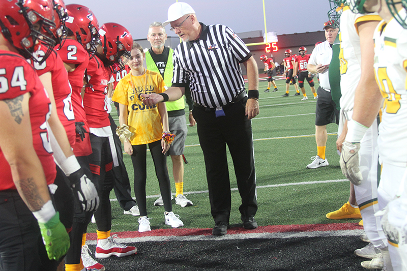 Huntley High School sophomore Madison Roberts was named honorary captain at the Red Raiders' Gold Out Game Sept. 29. From left: HHS football team captains Adam Tramuta, Vinny Triberi, Zack Garifo, Bryce Walker, Roberts, Athletic Director Glen Wilson and referee Wayne Miller.