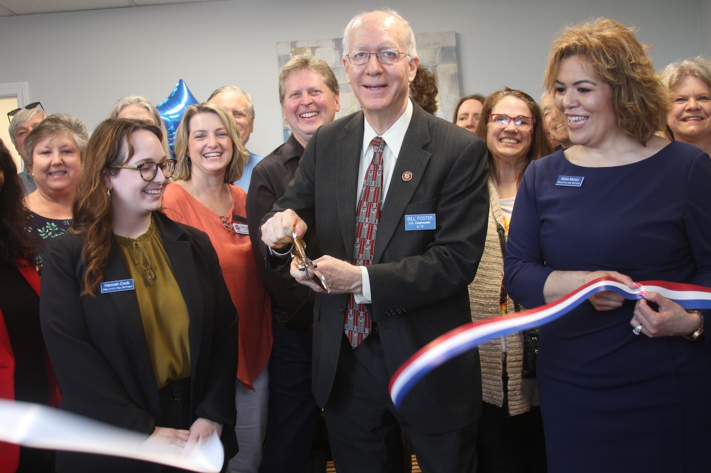 Illinois Congressman Bill Foster (D-11th) uses a gold scissors to cut the ribbon at his new district office in Huntley April 27.