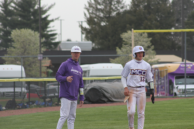 McHenry County College baseball coach Jared Wacker, left, talks to Kelli Grennier who takes a lead off third base.